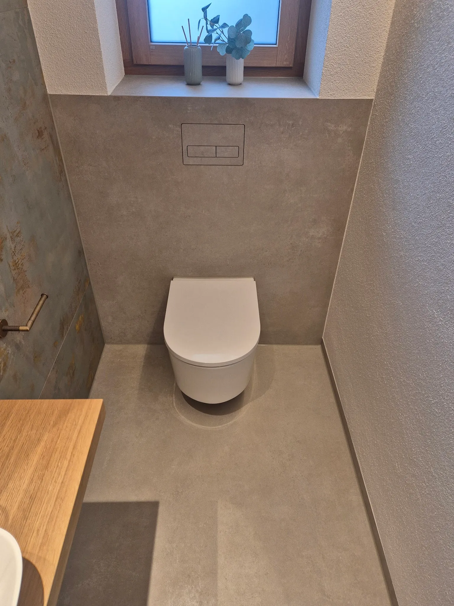 Gäste-WC mit grauen Großformaten an Boden und Wand