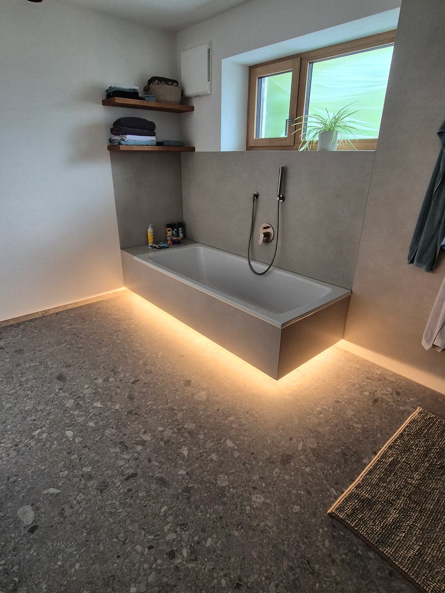 Badewanne mit gefliester Verkleidung und Lichtfuge, Terrazzo-Boden
