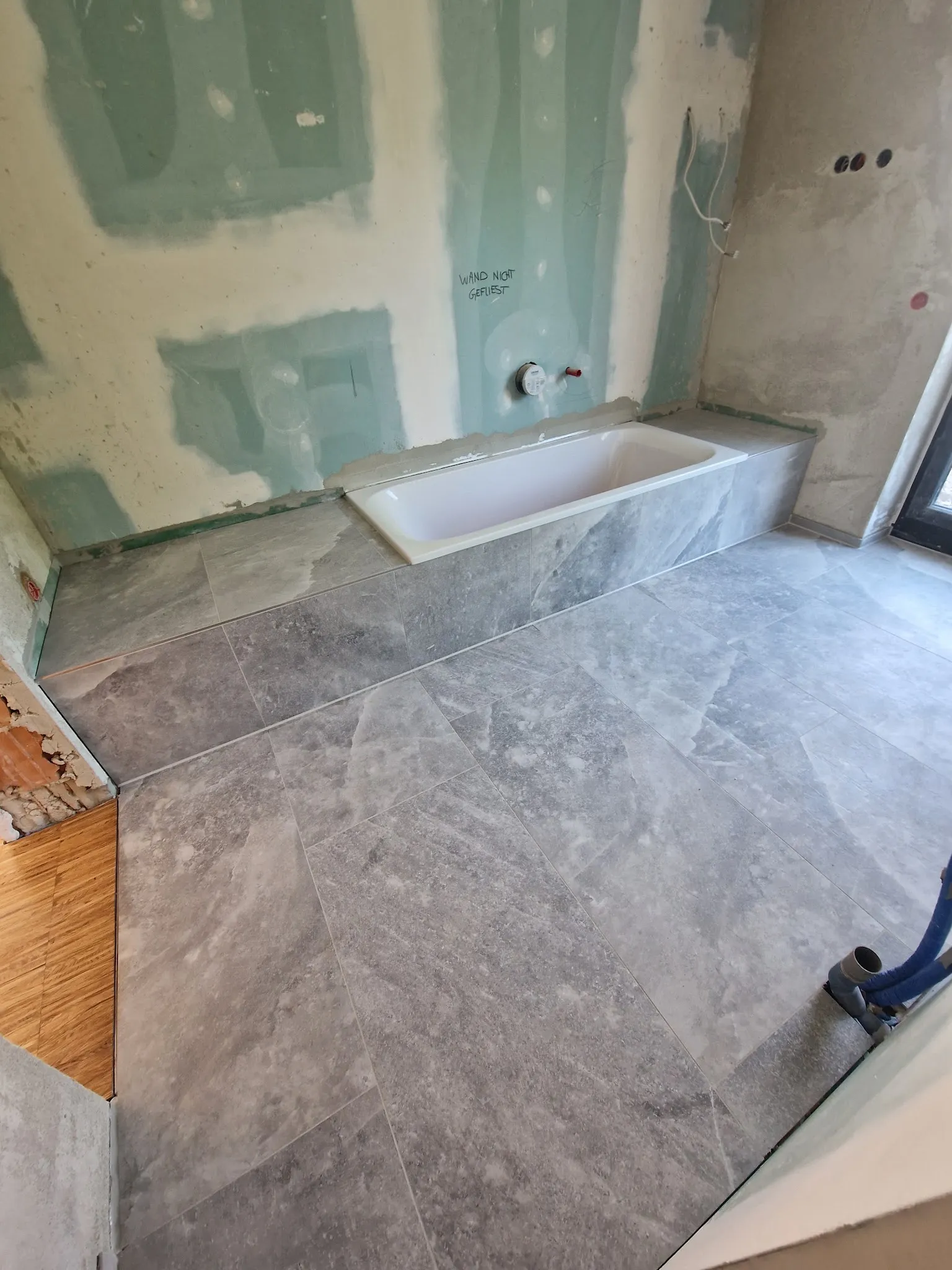 Bad mit Boden und Wannenverkleidung aus Platten in Stein-Optik