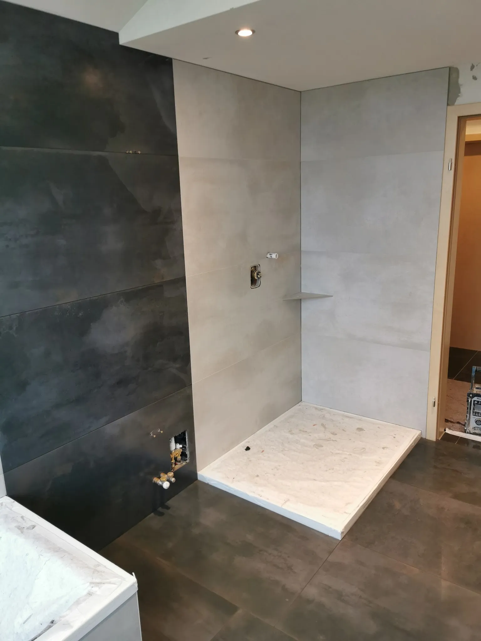 Dusche mit dunkler Akzentwand und hellen Großformaten