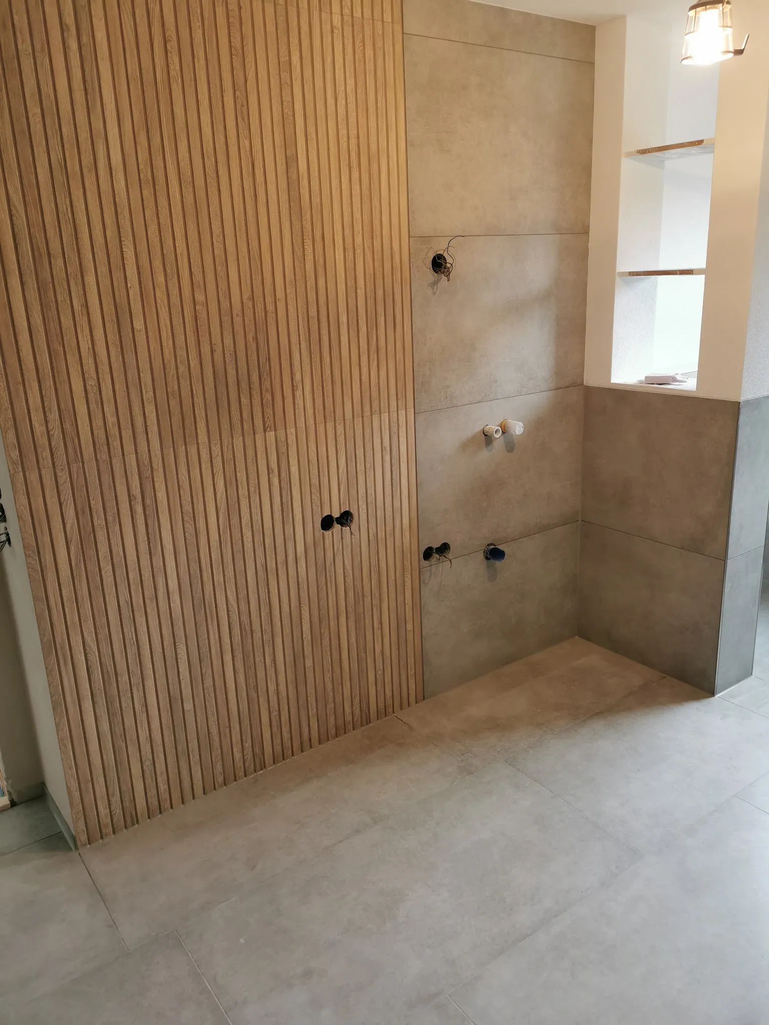 Bad mit Akzentwand in Holzlamellen-Optik und großen Platten