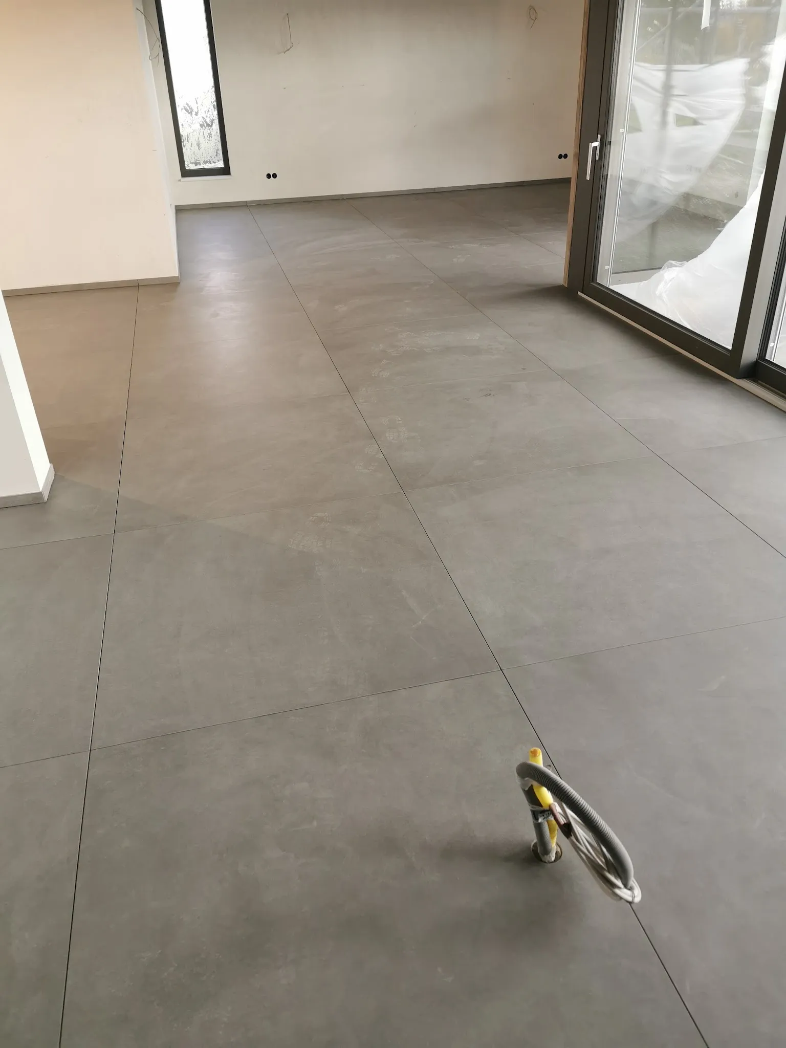 Großer Wohnraum mit grauem Boden aus Großformaten