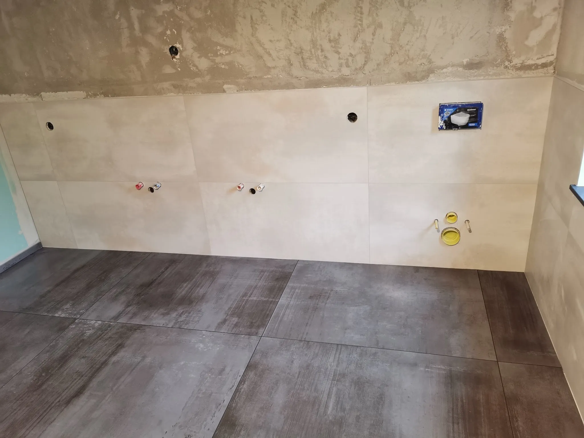 Bad mit hellen Wandplatten und Boden in Beton-Optik