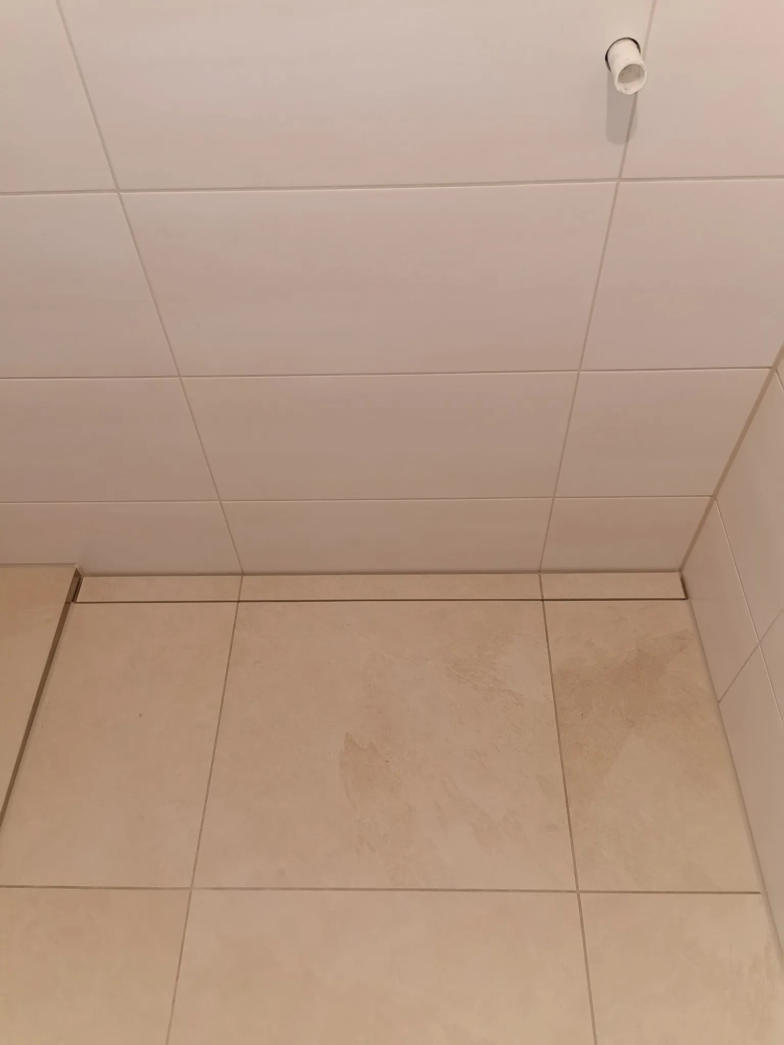 Bodengleiche Dusche mit hellen Großformaten und Duschrinne