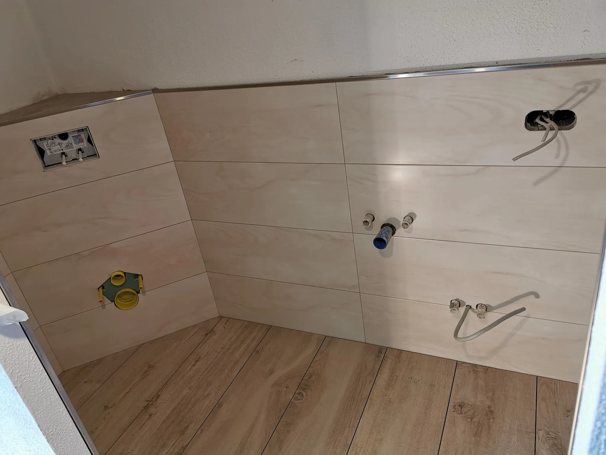 Bad mit hellen Wandfliesen und Boden in Holzoptik