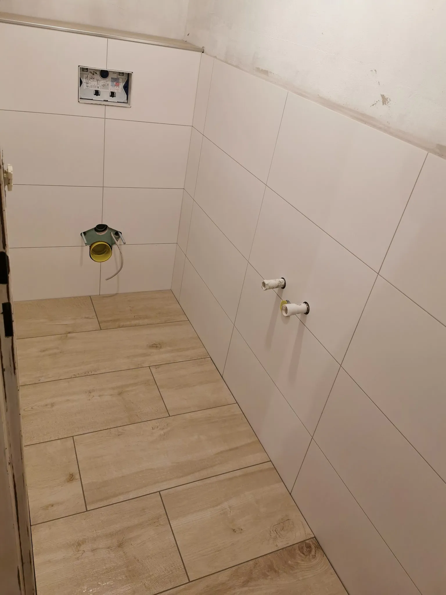 Dusche mit hellen Wandplatten und Boden in Holzoptik