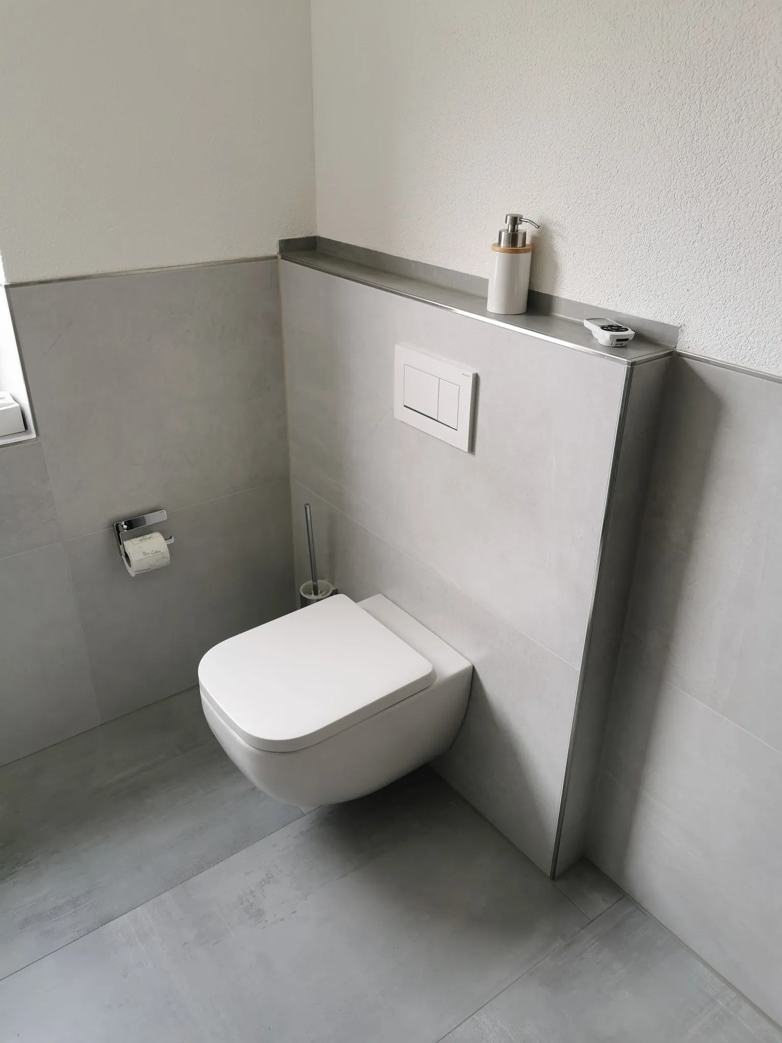 Gäste-WC mit grauen Wandplatten